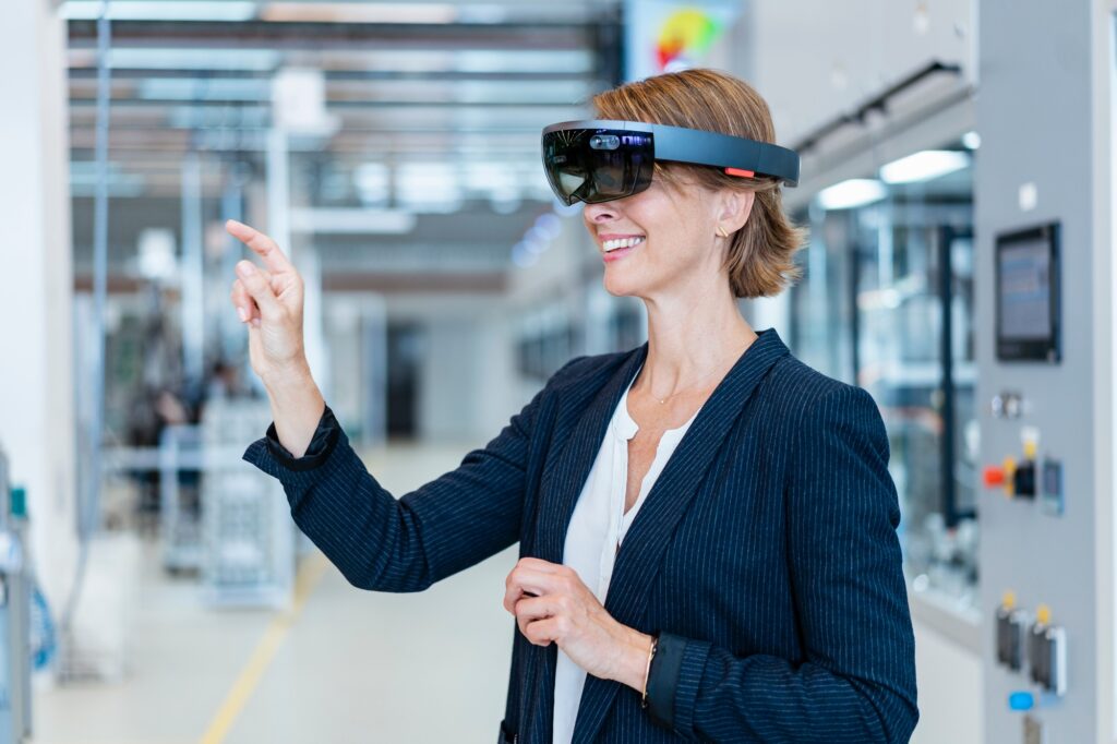Smiling businesswoman wearing AR glasses in a modern factory
